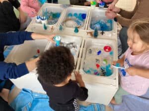 Enfants réunis autour d’un atelier d’exploration sensorielle